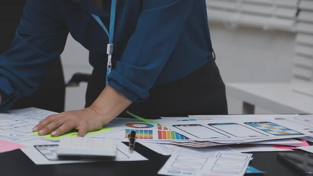 Professional woman working on UXUI design, creating wireframes and mockups for a mobile application while on a call