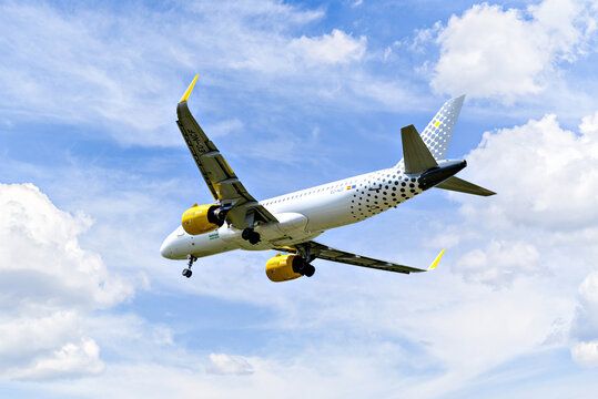 Barcelona, ​​Spain; April 5, 2025: A Vueling Airbus A320 landing at Josep Tarradellas Barcelona-El Prat Airport.	
