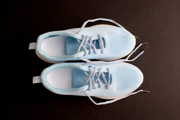 Women's summer blue sneakers stand on a black background.