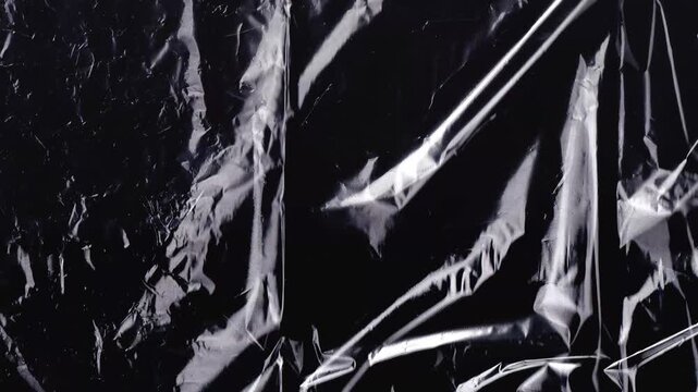 Black and white grunge plastic texture background. Abstract distressed graphic element motion. Crumpled surface backdrop. Suitable for film screen layout template.