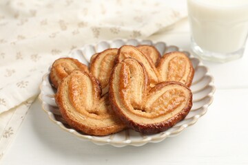 Fototapeta premium Yummy palmiers and milk on white wooden table, closeup