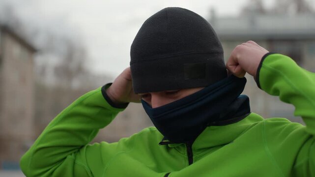 man adjusting gear before training, caucasian man ensuring clothing is perfect for outdoor cold training, male athlete making last adjustments to gear prior to cold weather workout session