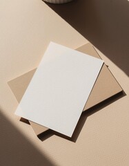 Minimalist blank white card on kraft envelope with natural light shadows