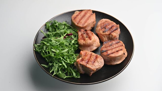 Grilled chicken with salad served on a black plate for a fresh meal experience