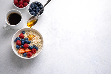 Delicious oatmeal with fresh berries and honey