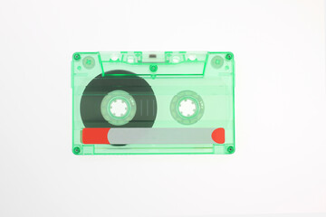 transparent green vintage retro music media audio cassette tape, with magnetic reels, visible magnetic reels and classic label design, analog sound nostalgic tech visuals, isolated on white background