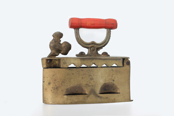 vintage charcoal iron, an antique household appliance historically used for pressing clothes before the advent of electricity,  with a small decorative rooster figure, isolated on a white background 