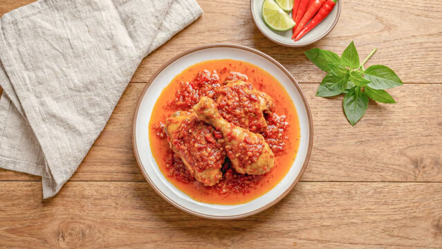 Authentic Ayam Balado. Fried chicken drumsticks coated in spicy red chili sambal. Traditional Padang Indonesian cuisine.