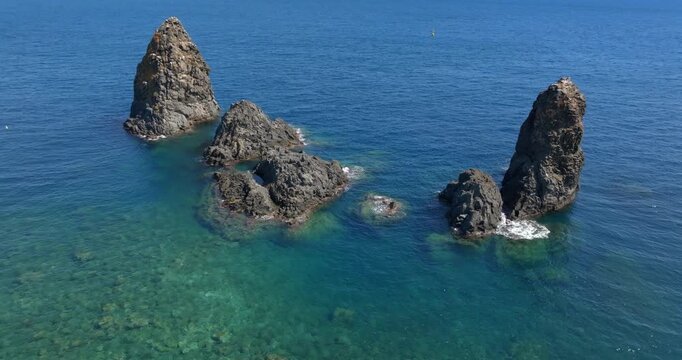 Aerial closeup of the Cyclopean Isles, noted for their rows of basaltic columns piled one above another, lie not far from Aci Trezza off the eastern coast of Sicily in the Mediterranean Sea, Italy. 