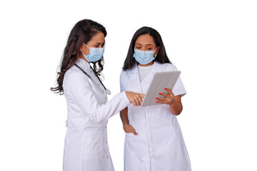 Female doctors wearing medical masks sharing digital tablet for discussing patient test results and healthcare data