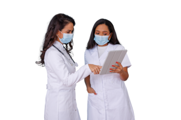 Female doctors wearing medical masks sharing digital tablet for discussing patient test results and healthcare data