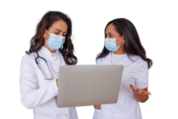 Two female doctors in medical uniforms and face masks collaborating, analyzing patient information on a laptop during a professional discussion