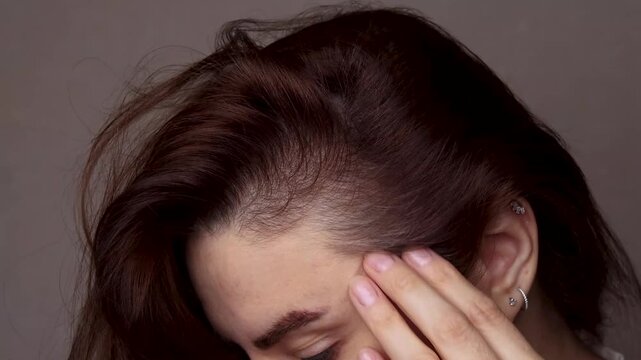 Caucasian brunette woman, shows the first gray hair. Copy space footage 4k