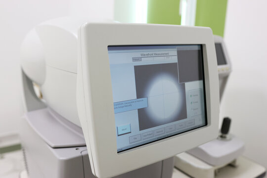 Modern autorefractor with monitor, keyboard, and mouse in a white clinical setting, used for automated eye measurements to determine refractive errors accurately.