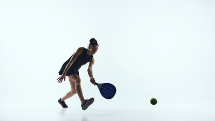 Female padel athlete prepares ready stance waiting for ball. Concept of padel training, technical positioning and advertising content for fitness and sport marketing.