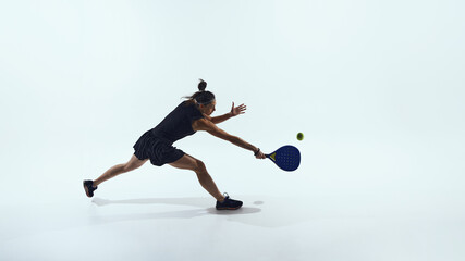 Padel player stretches forward reaching ball in full motion. Concept of padel speed, effort and dynamic advertising visuals for athletic performance brands.