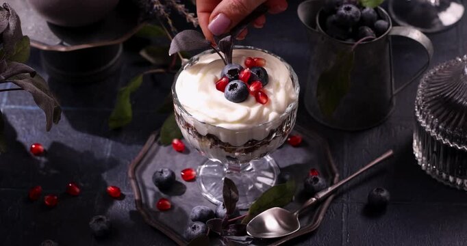 Hand decorating delicious berry parfait dessert