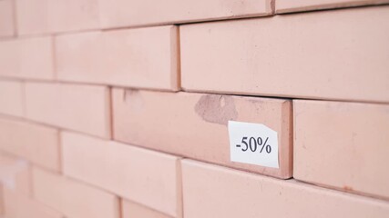 A minus 50 percent discount is applied to damaged decorative bricks. Selling defective ones is cheaper