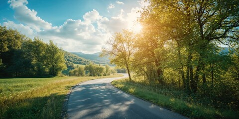 Obraz premium Meandering asphalt pathway in picturesque rural landscape, suitable for travel and navigation