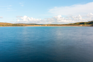 Fototapeta premium Melvich Bay. Scotland, NC500 route. Calm coastal landscape with blue sea, sandy shore, and wide open sky