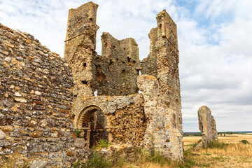 Bawsey ruin, near King's Lynn, Norfolk. ancient stone castle ruins standing amid golden fields under a bright sky