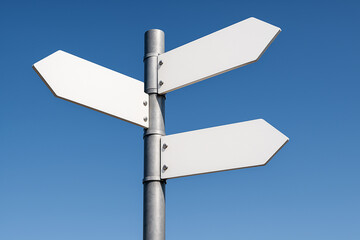 A metal post with three blank, white directional arrow signs against a clear, vibrant blue sky, representing choice, direction, or decision-making