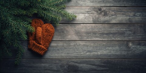 Gray wooden surface with mittens and pine branches, winter holiday crafting