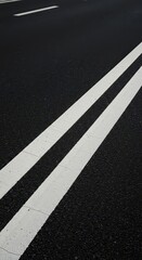 Fototapeta premium Diagonal perspective of thick parallel white lines painted on black street asphalt, symbolizing road safety and movement in an urban area, safety, graphic, road