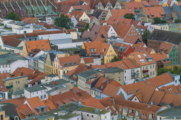 Aerial view of terracotta rooftops cascade across the cityscape, a tapestry of warm hues against the backdrop of aged brick and verdant foliage, Stralsund, Mecklenburg-Vorpommern, Germany.