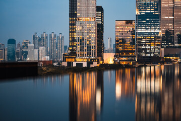 Fototapeta premium big city skyline at sunset with mirrored water reflection, modern high-rise skyscrapers at golden hour urban dusk, downtown mirroring on calm lake or pond, Bangkok Thailand