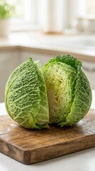 Fototapeta premium Fresh Green Cabbage Halved with Textured Leaves on Wooden Cutting Board