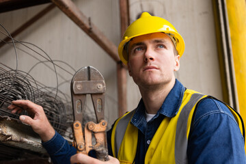 Skilled construction worker holding bolt cutter on site