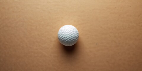 White golf ball on a cardboard background, highlighting sports equipment and gameplay focus, International Sports Day