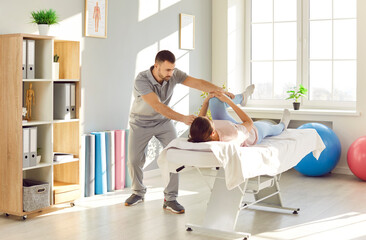 Professional physiotherapist or chiropractor at work. Man doctor examining the leg of a female...