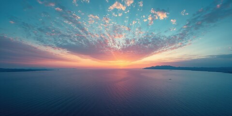 Obraz premium Panoramic shot of a sunrise over a calm sea with vibrant orange and blue tones, highlighting natural beauty, Earth Day