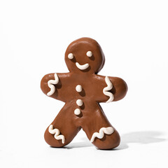Gingerbread man made of plasticine on a white background. Christmas card template.