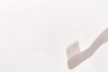 Abstract shadow of a comb on white background suggesting minimalism and simplicity in design.