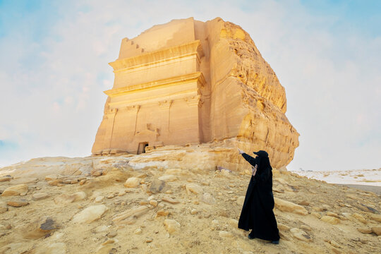 Woman exploring ancient qasr al farid nabataean tomb, AlUla, Saudi Arabia