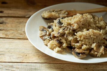 Flavorful Rice Dish With Mushrooms Prepared on a Wooden Table