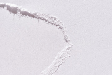 Close-up of torn white paper edge showing textured fibers and clean tear line on a smooth surface.