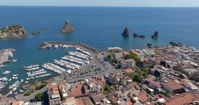 Aerial view of the town of Aci Trezza overlooking the Mediterranean Sea, in the province of Catania, Sicily, Italy. In the background, on the horizon, are the Cyclopean Isles or islands of the Cyclops