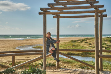 Young woman relaxing on beach pergola enjoying vacation