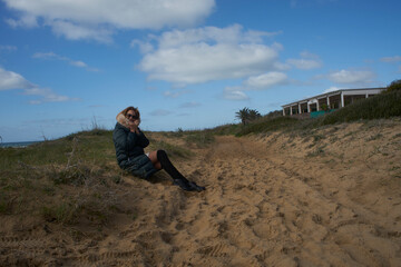 Woman relaxing on sandy beach dune enjoying sunny day