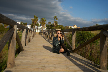 Woman sitting boardwalk in urban beach landscape