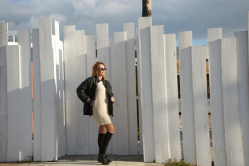 Woman wearing leather jacket and sunglasses posing outdoors