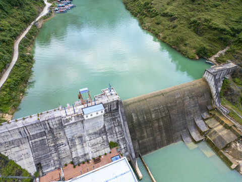 Aerial view of the dam holding back the turquoise water, the structure a stark contrast to the surrounding verdant landscape, Long Phu, Soc Trang, Vietnam.