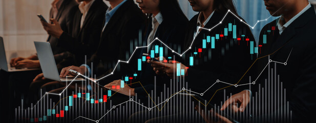 A group of business professionals in a modern workspace, engaging with tech devices. Abstract growth charts overlay symbolize dynamic finance and market analysis. Scalp