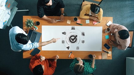 A top view of a creative team engaged in brainstorming and planning at a modern office. They...