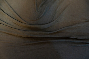 Textured black fabric drapes elegantly, showcasing folds and shadows. Ideal for background, design...