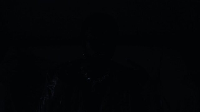 High angle static shot of fashionable African American woman wearing metallic evening dress and statement jewelry dancing gracefully in strobe light flashes in studio, copy space